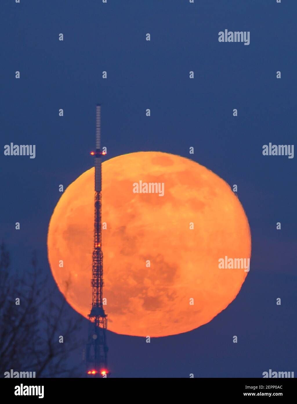 Londres, Royaume-Uni. 27 février 2021. Full Snow Moon s'élève derrière la tour d'émetteur de 219 mètres de haut Crystal Palace dans le sud de Londres. (Remarque : les câbles d'alimentation de premier plan ont été retirés numériquement sur cette image). Crédit: Malcolm Park/Alay Banque D'Images