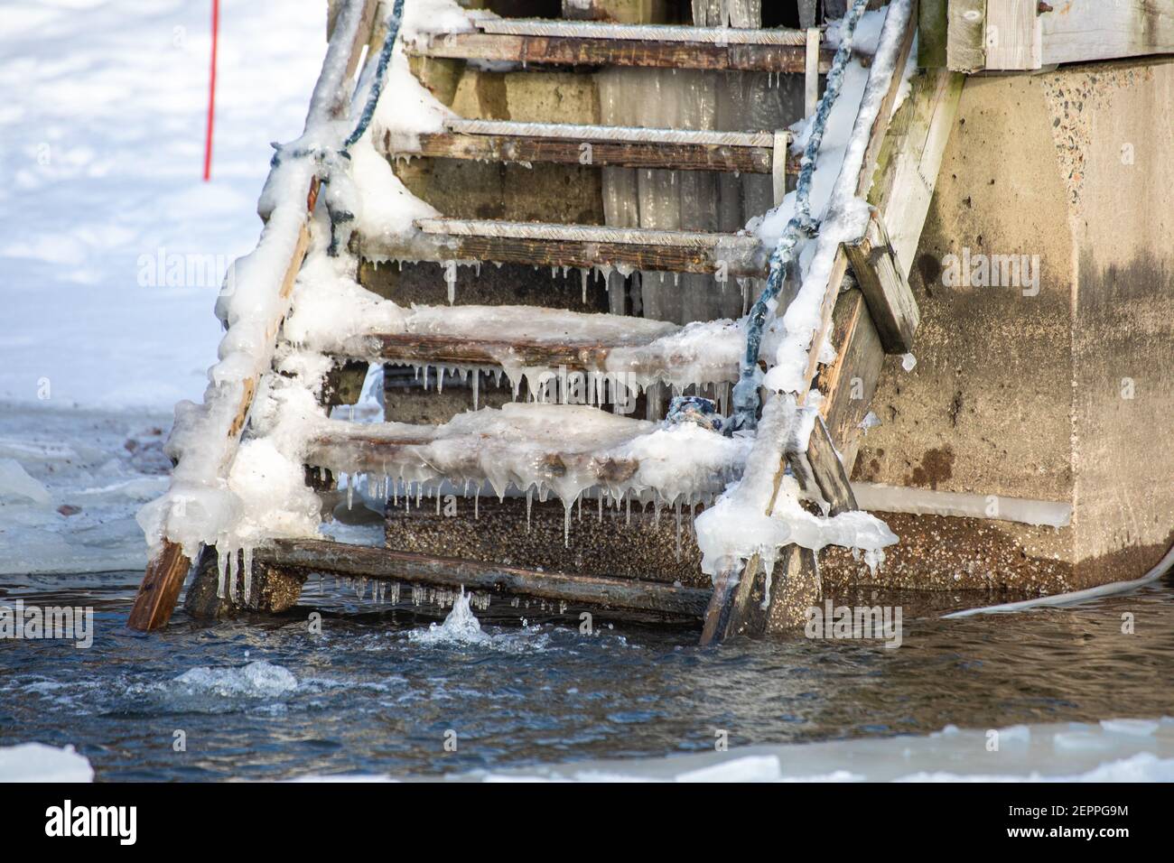 Escaliers glacés menant à un trou dans la glace pour la baignade en hiver sur la plage de Munkkiniemenranta dans le quartier de Munkkiniemi à Helsinki, en Finlande Banque D'Images