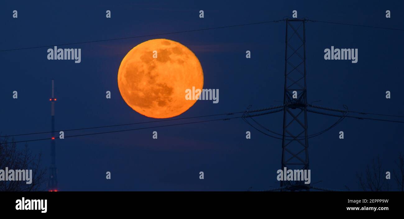 Londres, Royaume-Uni. 27 février 2021. Full Snow Moon s'élève derrière un pylône électrique dans le sud de Londres avec la tour de 219 mètres de haut de l'émetteur Crystal Palace à gauche du cadre. Crédit: Malcolm Park/Alay Banque D'Images