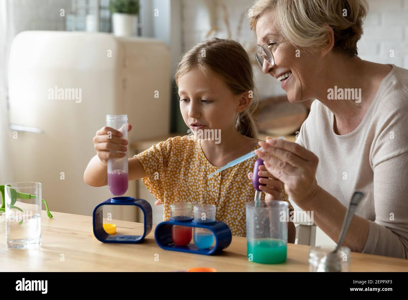 Femme mature tuteur enseigner la chimie de petite fille dans le jeu d'éducation Banque D'Images