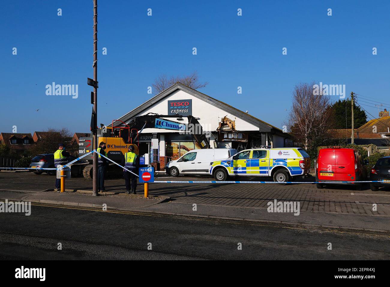 Dymchurch, Kent, Royaume-Uni. 28 février 2021. Les voleurs enhardis ont tenté un RAID audacieux sur ce Tesco express dans la rue Dymchurch Hugh après avoir conduit une excavatrice sur chenilles Volvo ECR235E dans les premières heures de la matinée, lors d'une tentative de vol en espèces. Un magasin a été laissé avec des "dommages importants" dans une tentative infructueuse de déchirer une machine à billets avec un creuseur, selon la police. Un coin du bâtiment se trouve en tatters. On croyait que le creuseur avait été volé à Dymchurch Beach. Crédit photo : Paul Lawrenson/Alay Live News Banque D'Images