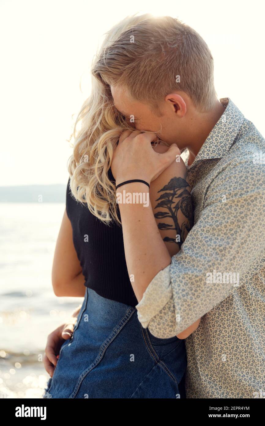 Jeune homme qui embrasse une petite amie émotionnelle à Beach Banque D'Images