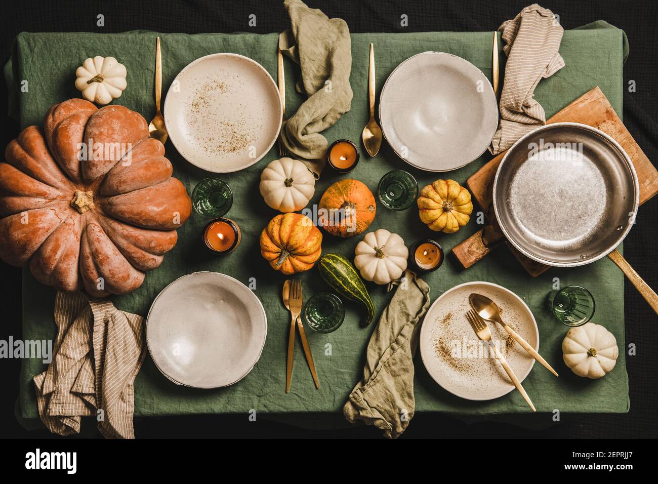 Table d'automne pour un dîner en famille, un rassemblement d'amis ou une  fête de Thanksgiving. Vaisselle, couverts et décoration de citrouille sur  fond de nappe en lin vert, vue du dessus Photo