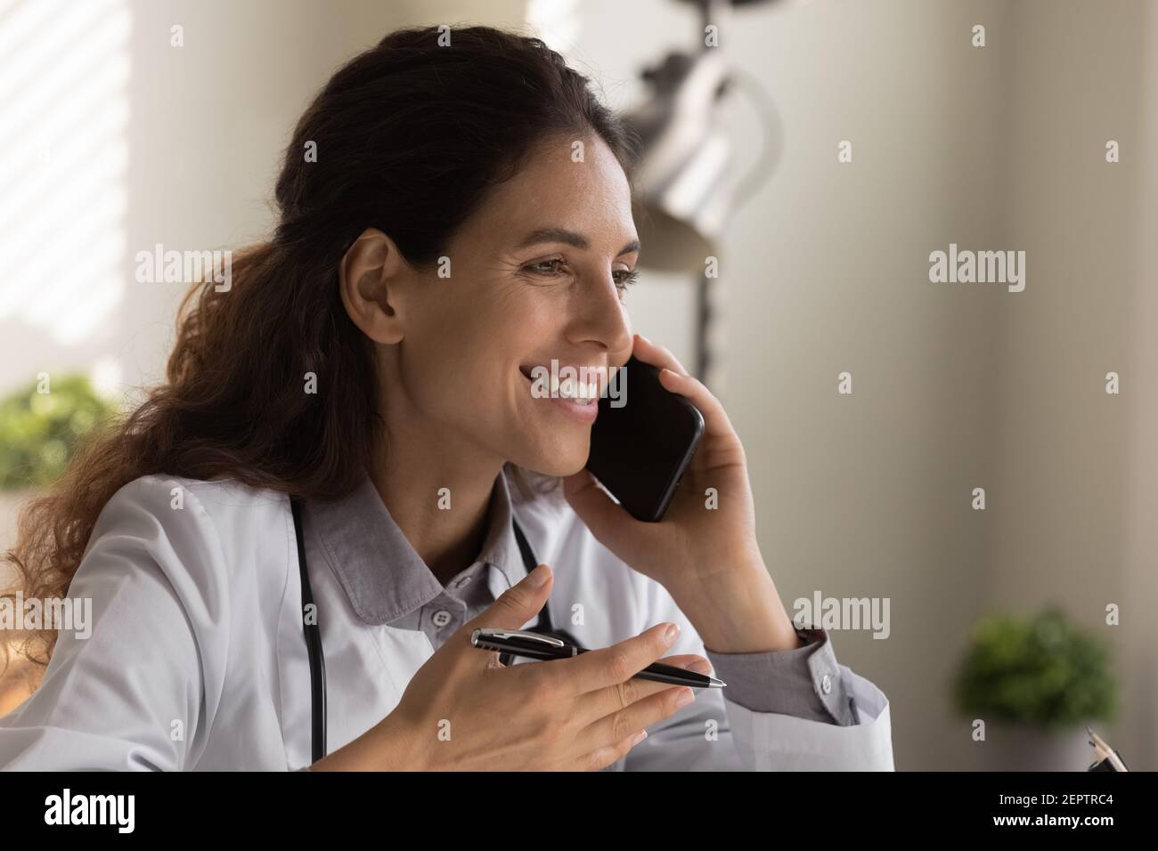 Gros plan femme souriante médecin parlant au téléphone, consultant le patient Banque D'Images