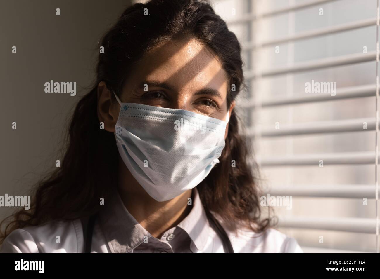 Prise de vue de la tête sourire femme médecin portant un masque de protection Banque D'Images