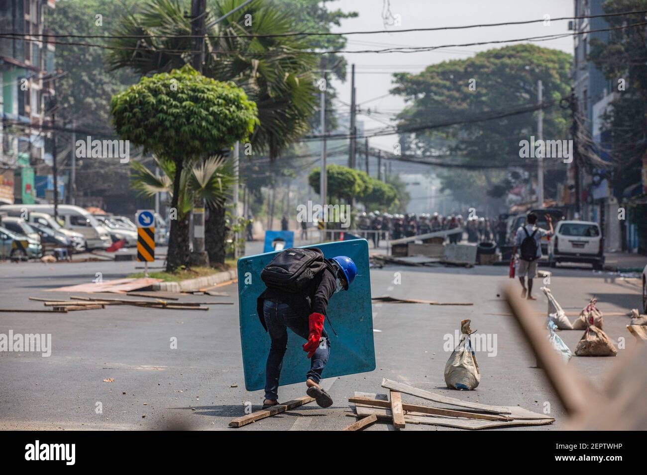 Les manifestants anti-coup d'État militaire sont confrontés à la police en utilisant un gros morceau de plastique comme bouclier pour se protéger lors d'une manifestation contre le coup d'État militaire.la police du Myanmar a incendié des balles en caoutchouc, de véritables balles, des gaz lacrymogènes et des bombes sonores à des manifestants pacifiques anti-coup d'État militaire dimanche, cent personnes ont été arrêtées, dont 50 membres du personnel médical et 1 journaliste. Au moins 7 personnes ont été tuées et tuées alors que le Myanmar entre dans la journée la plus sanglante depuis le coup d'État militaire du 1er février 2021. L'armée du Myanmar a détenu le conseiller d'État du Myanmar Aung San Suu Kyi le 01 février 2021 et a déclaré l'état de Banque D'Images