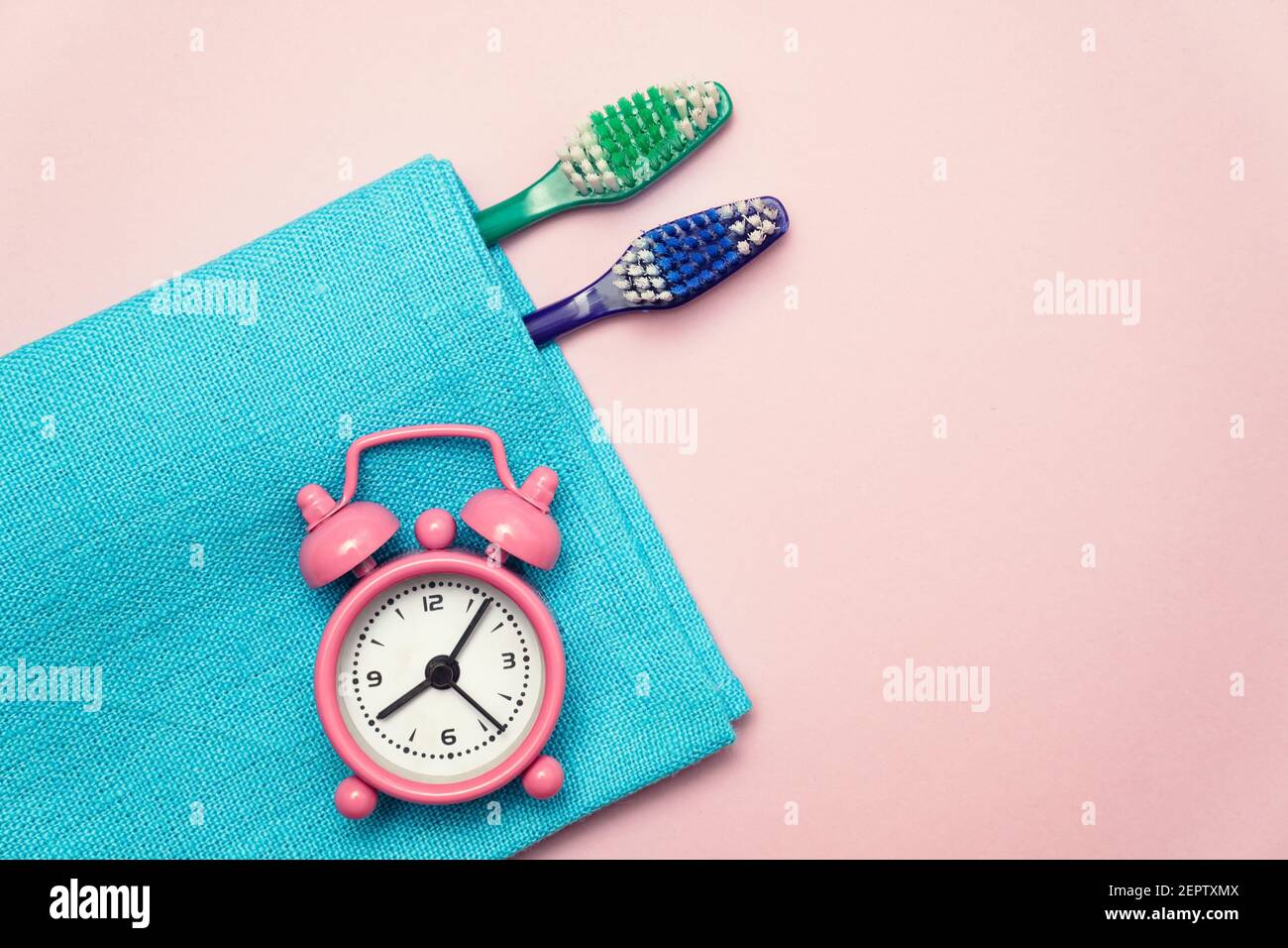 Plat avec brosse à dents et réveil pour les soins dentaires sur fond rose Banque D'Images