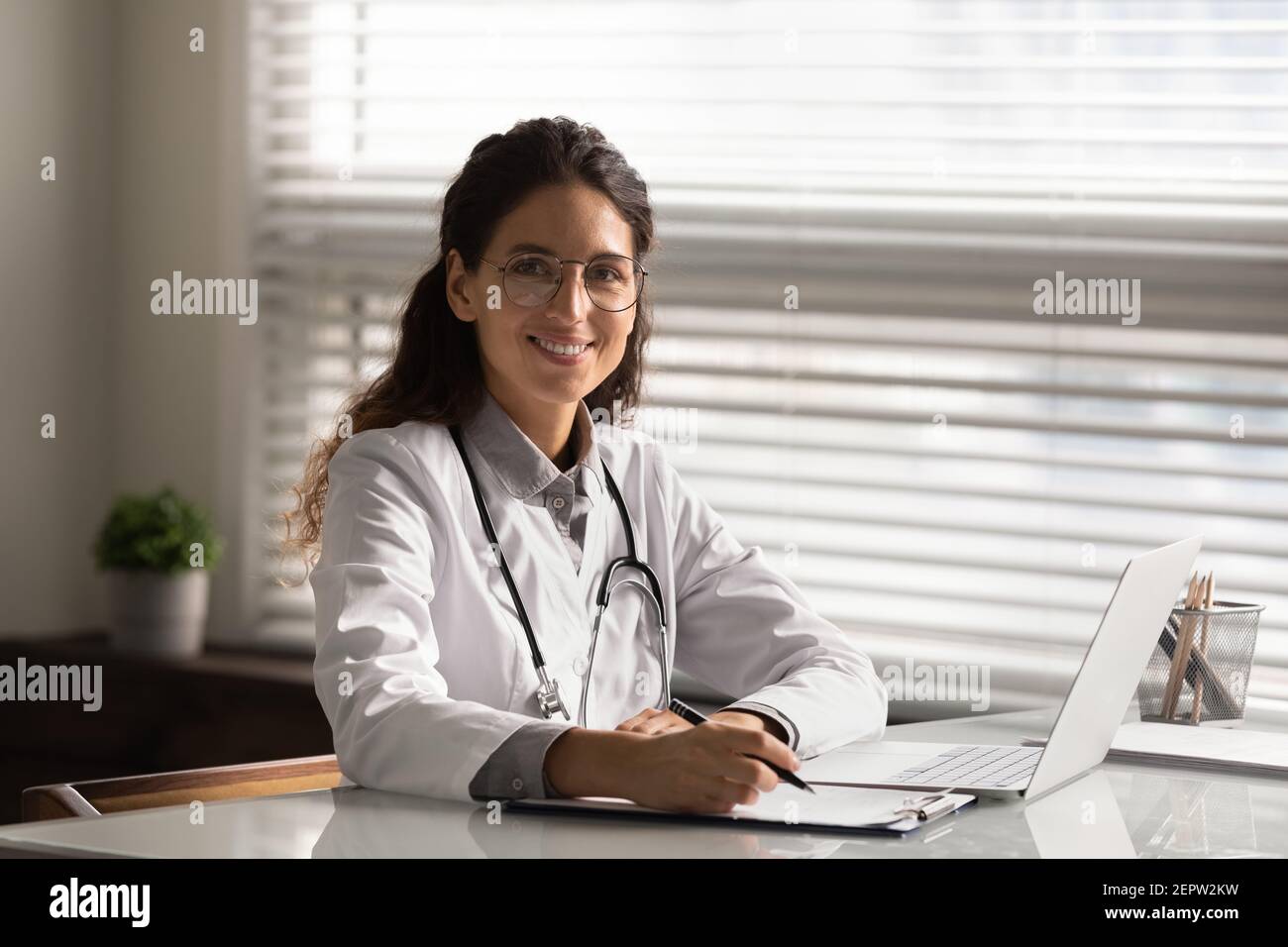 Portrait de la tête souriante femme médecin remplissant des documents médicaux Banque D'Images