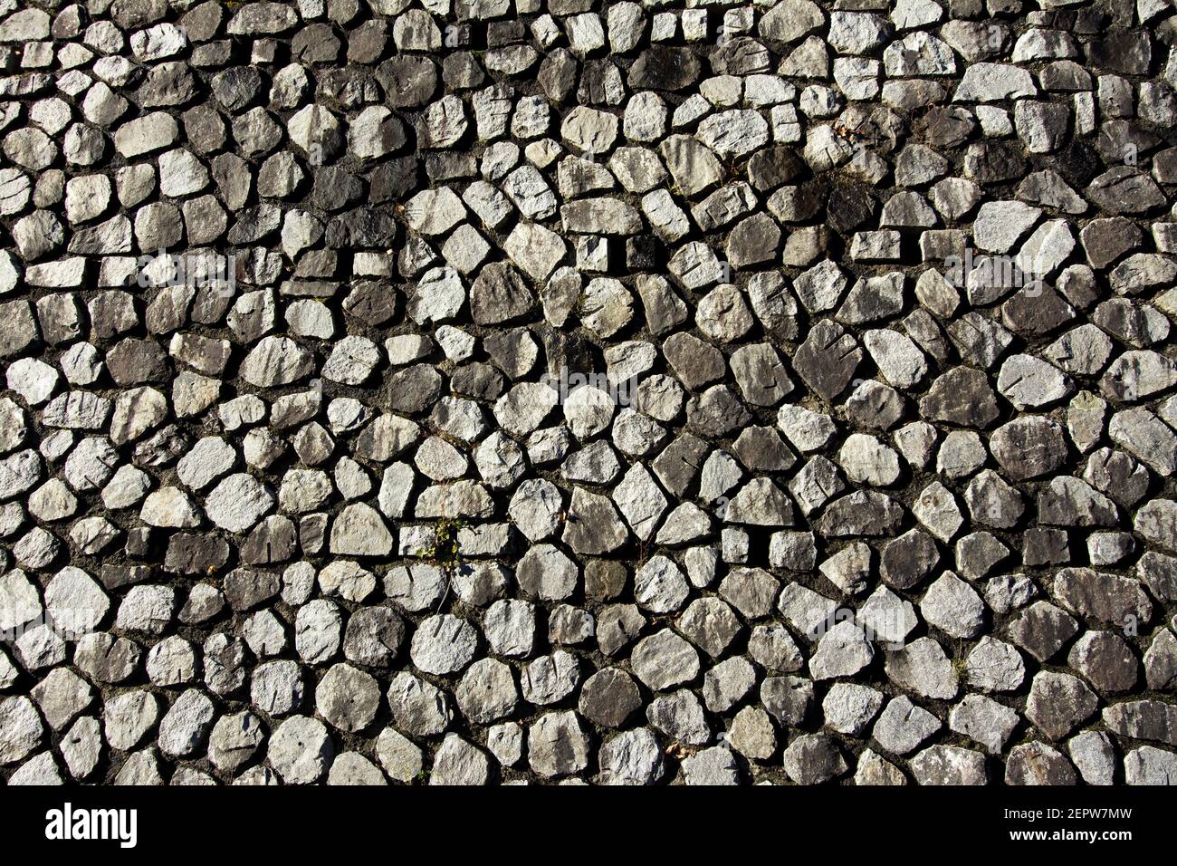 Motif mural en pierre texturée présentant différentes formes et tailles de pierres dans un arrangement naturel mettant en évidence différentes teintes Banque D'Images