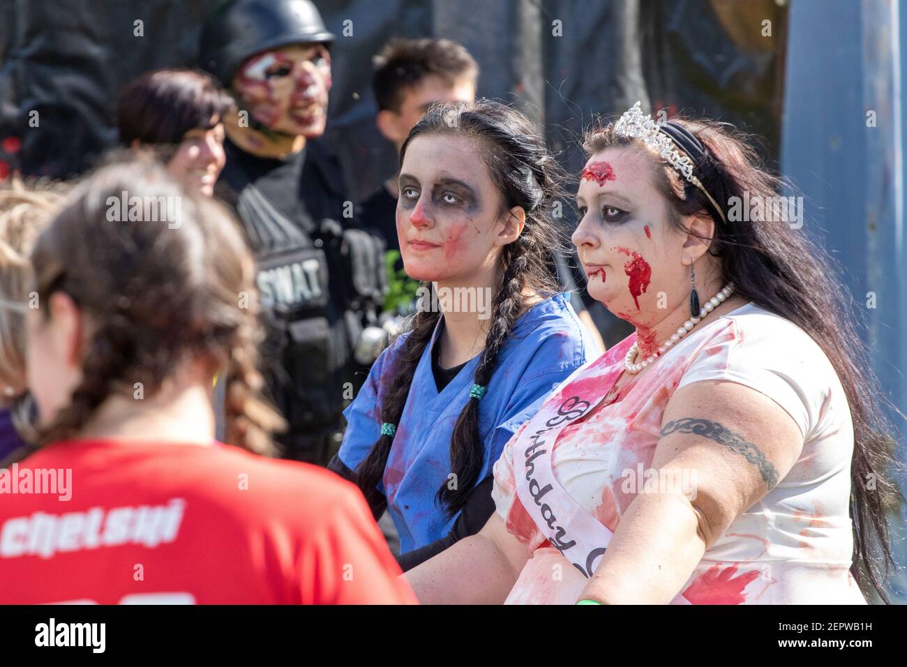 Une « fille d'anniversaire » qui ressemble beaucoup à une mariée et un Infirmière en exfoliant après un événement d'évacuation Zombie dans le Campagne de Norfolk Banque D'Images