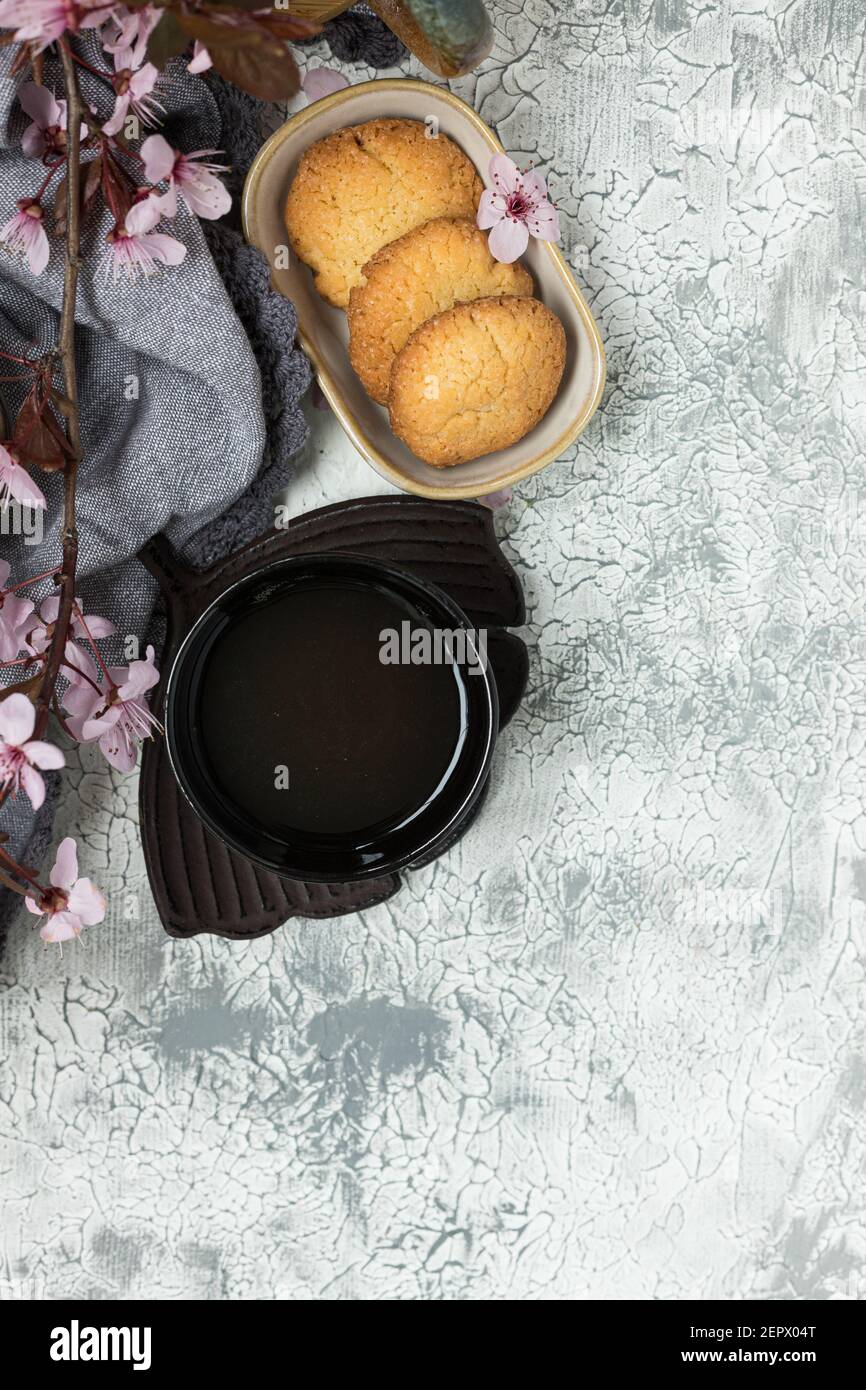 Une tasse de café élégante et un plat en forme de feuilles à côté de trois délicieux biscuits dans un plateau Banque D'Images