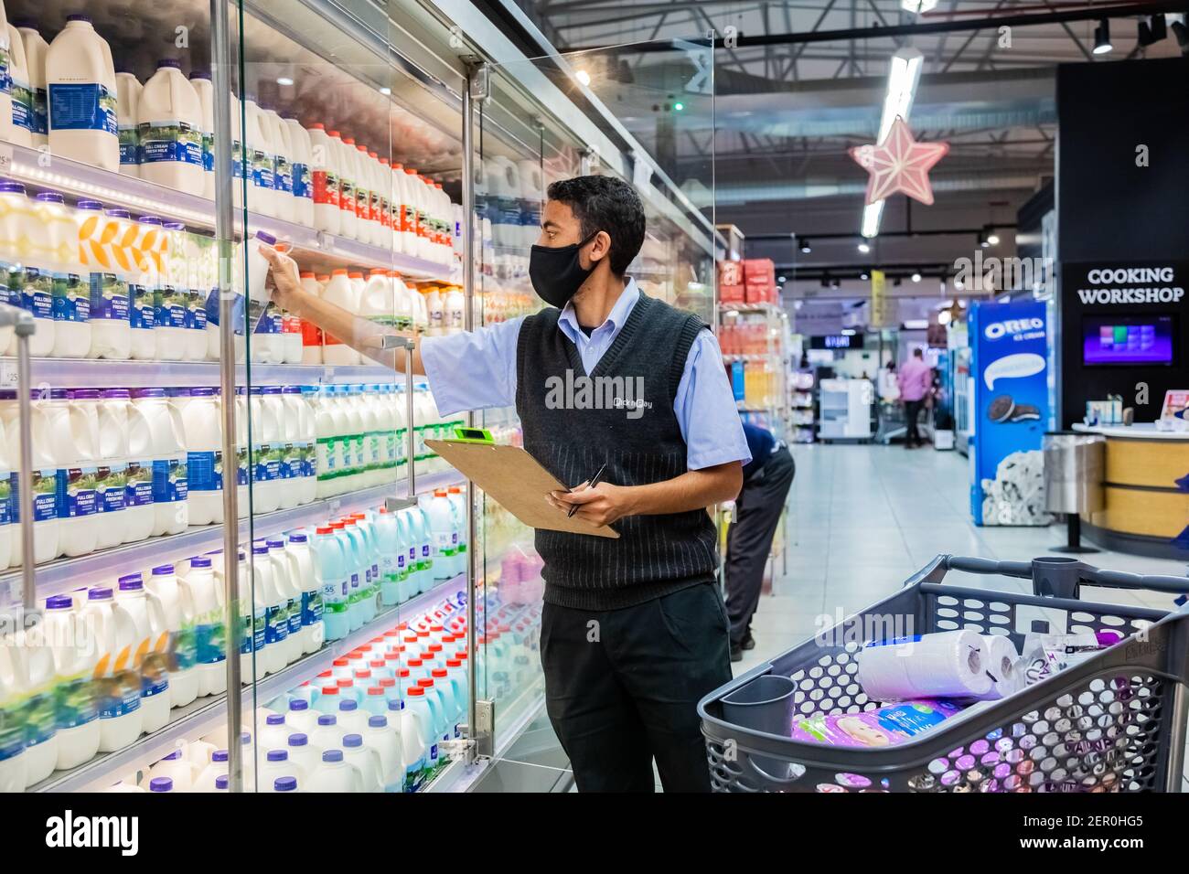 Cape Town, Afrique du Sud - 10 décembre 2020 : membre du personnel qui cueille les produits d'épicerie de l'étagère pour un service de livraison express à domicile au service local Pick n Pay su Banque D'Images