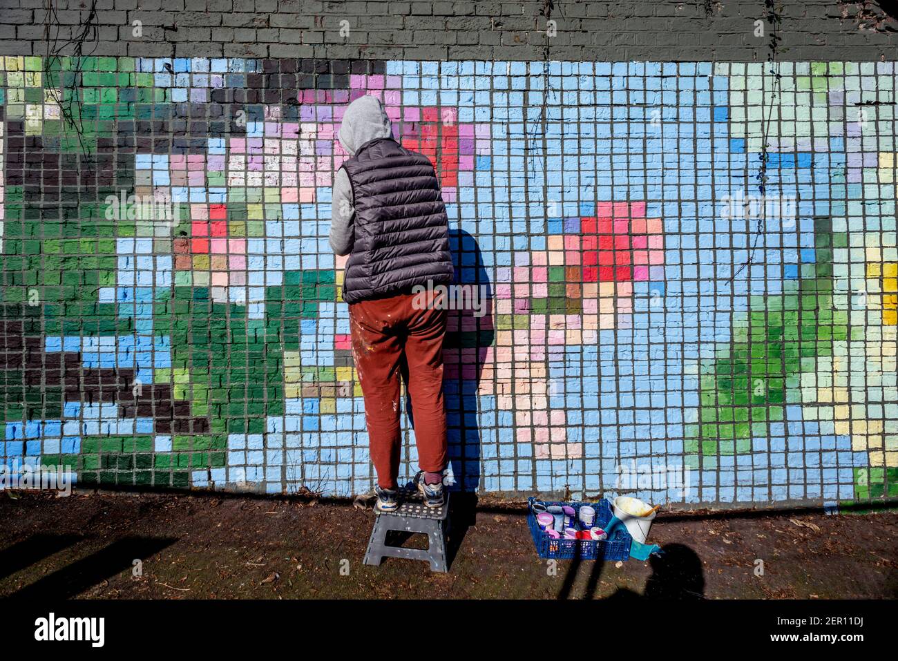 Brighton, 28 février 2021 : l'artiste locale Christina Ure profite du soleil pour peindre une fresque communautaire sur l'entrée négligée et sujette aux graffitis d'un tunnel ferroviaire à Brighton. Une fois terminé, le travail sera couvert de peinture anti-vandalisme pour éviter d'autres dommages. Crédit : Andrew Hasson/Alamy Live News Banque D'Images