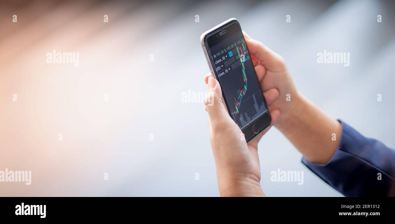 Téléphone portable à main levée avec graphique d'analyse et tableau de  tendance avec application de marché de stock-set qui partout peut être en  négociation Photo Stock - Alamy