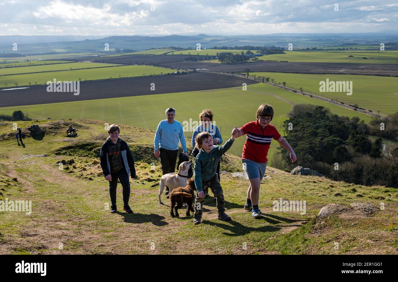 North Berwick, East Lothian, Écosse, Royaume-Uni, 28 février 2021.Escalade de la loi de Berwick pour le syndrome de Rett: Nina McKinney, âgée de sept ans, termine son but de grimper la colline de 613 pieds, reste d'une prise volcanique, chaque jour ce mois-ci pour recueillir de l'argent pour Reverse Rett, une œuvre de charité qui soutient la recherche sur le désordre dont sa sœur souffre.Son objectif était de £250 mais a jusqu'à présent augmenté plus de £3,000.Photo: Nina donne à son frère plus jeune Felix, âgé de 4 ans, une main d'aide comme elle et sa famille grimper la colline avec leurs chiens.Nina a bravé tous les temps en février Banque D'Images