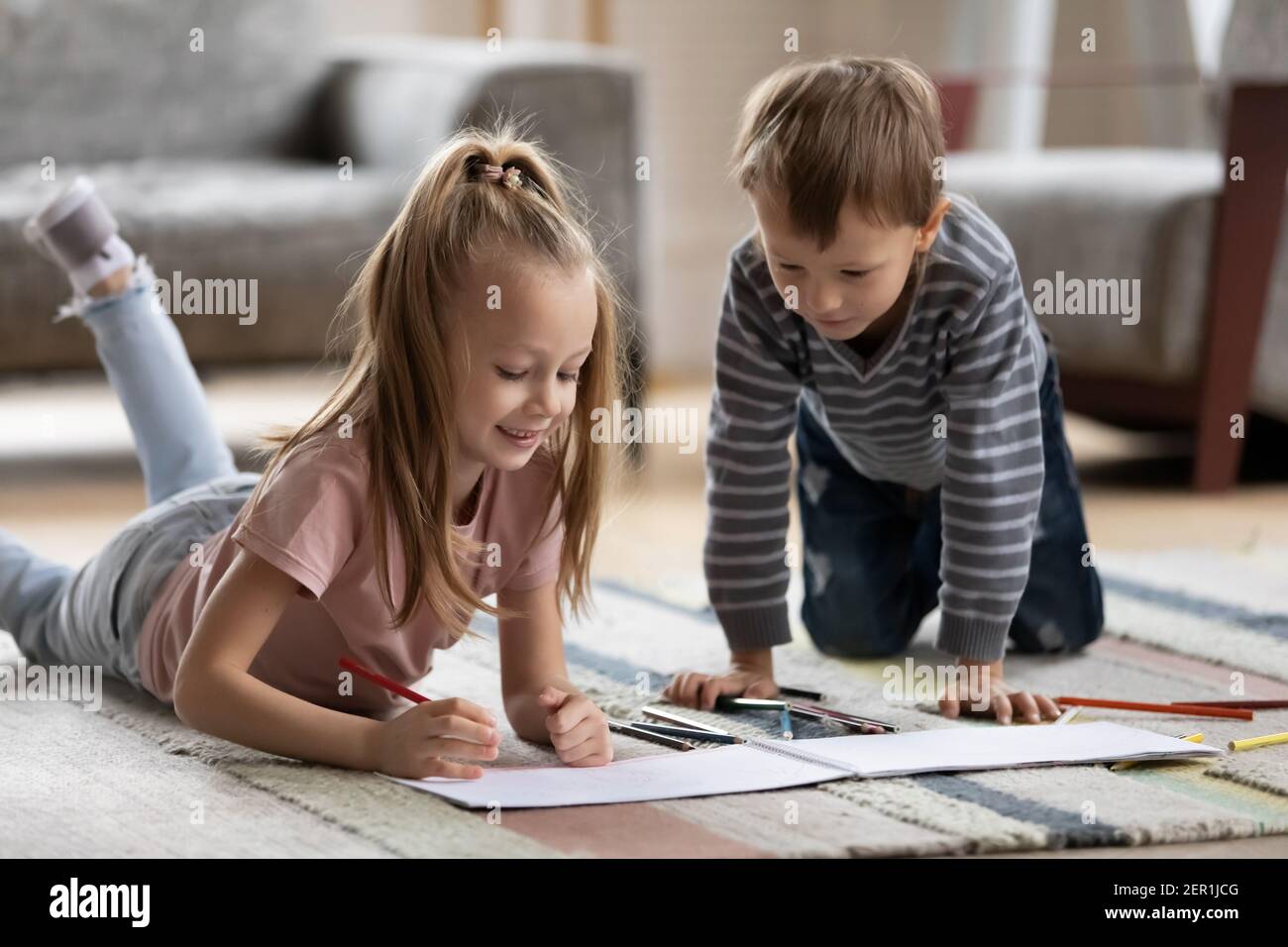 Deux adorables enfants d'âge préscolaire qui desseignent dans des albums en papier Banque D'Images