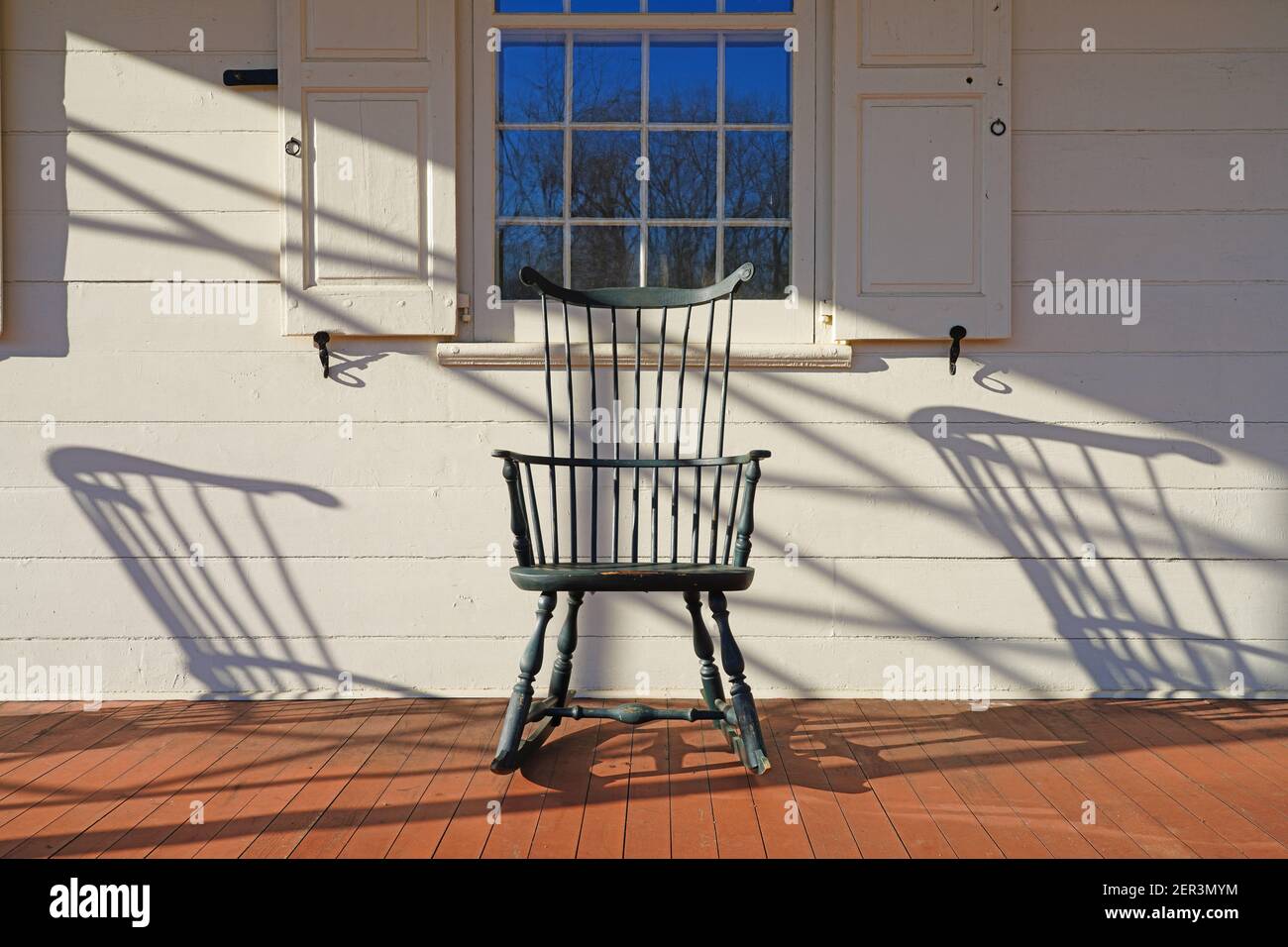 Vue sur un ancien fauteuil à bascule avec des broches en bois sur une maison porche dans la ville historique de Walnford, New Jersey, États-Unis Banque D'Images