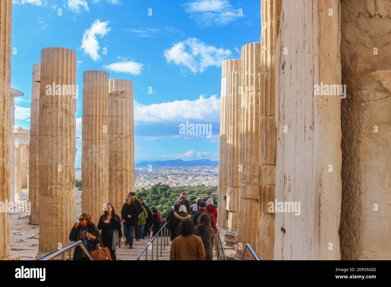 1-12-2018 Athènes, Grèce- touristes sortant et entrant dans le complexe Parthénon sur l'Acropole d'Athènes en hiver avec Athènes et les montagnes dans le Th Banque D'Images