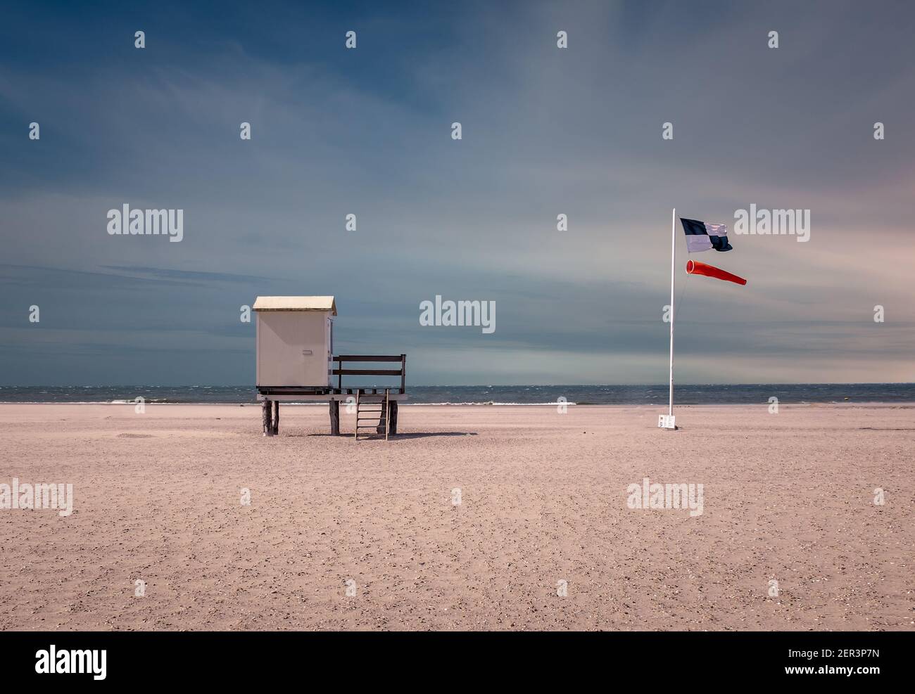 Refuge de sauveteurs avec une chaussette à vent et un drapeau de sécurité sur une plage à Zeeland, aux pays-Bas Banque D'Images