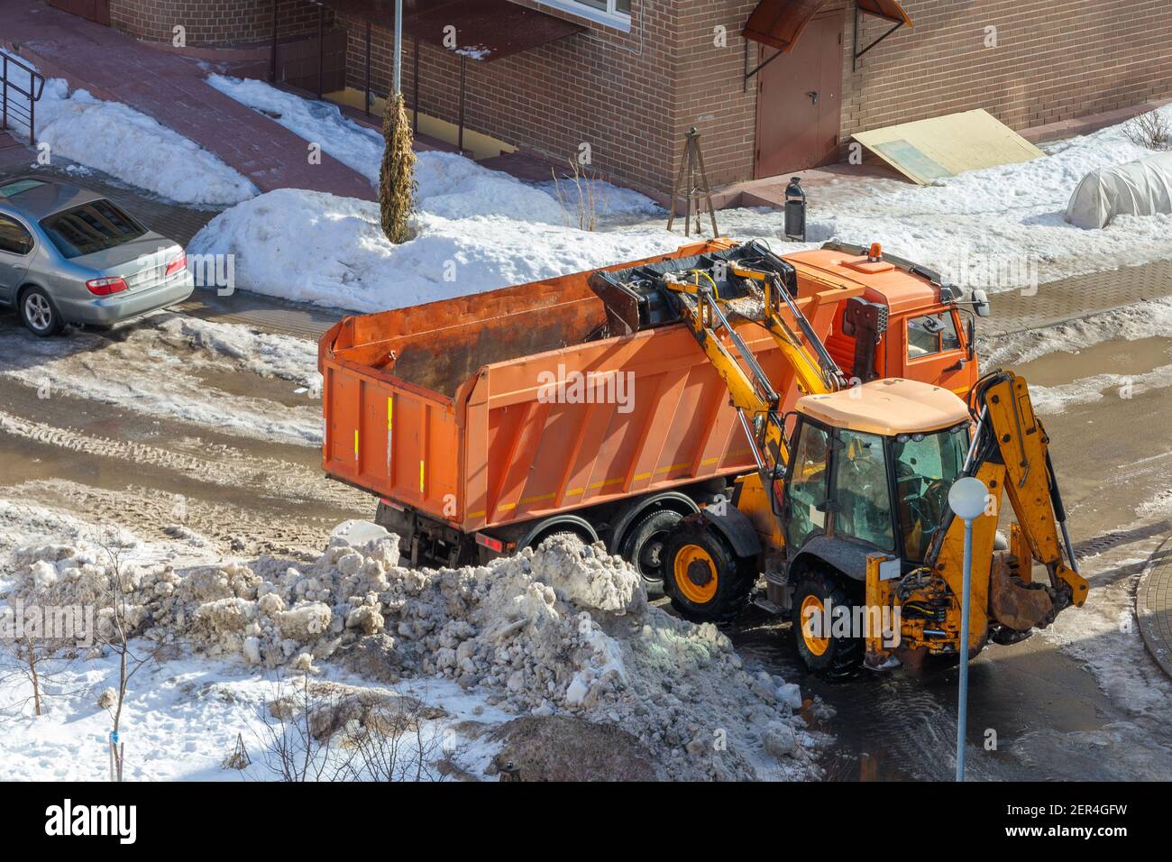Pelle hydraulique déneigement de la route en hiver Photo Stock - Alamy