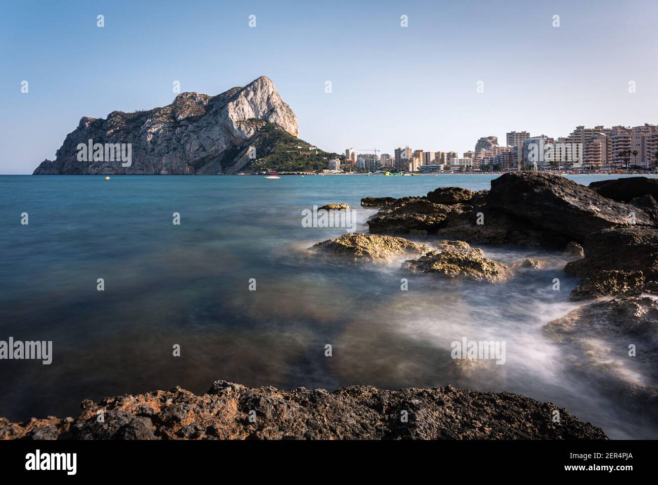 Vue depuis les rochers de la côte avec la plage urbaine de Calpe et le crag en arrière-plan, Alicante, Espagne Banque D'Images