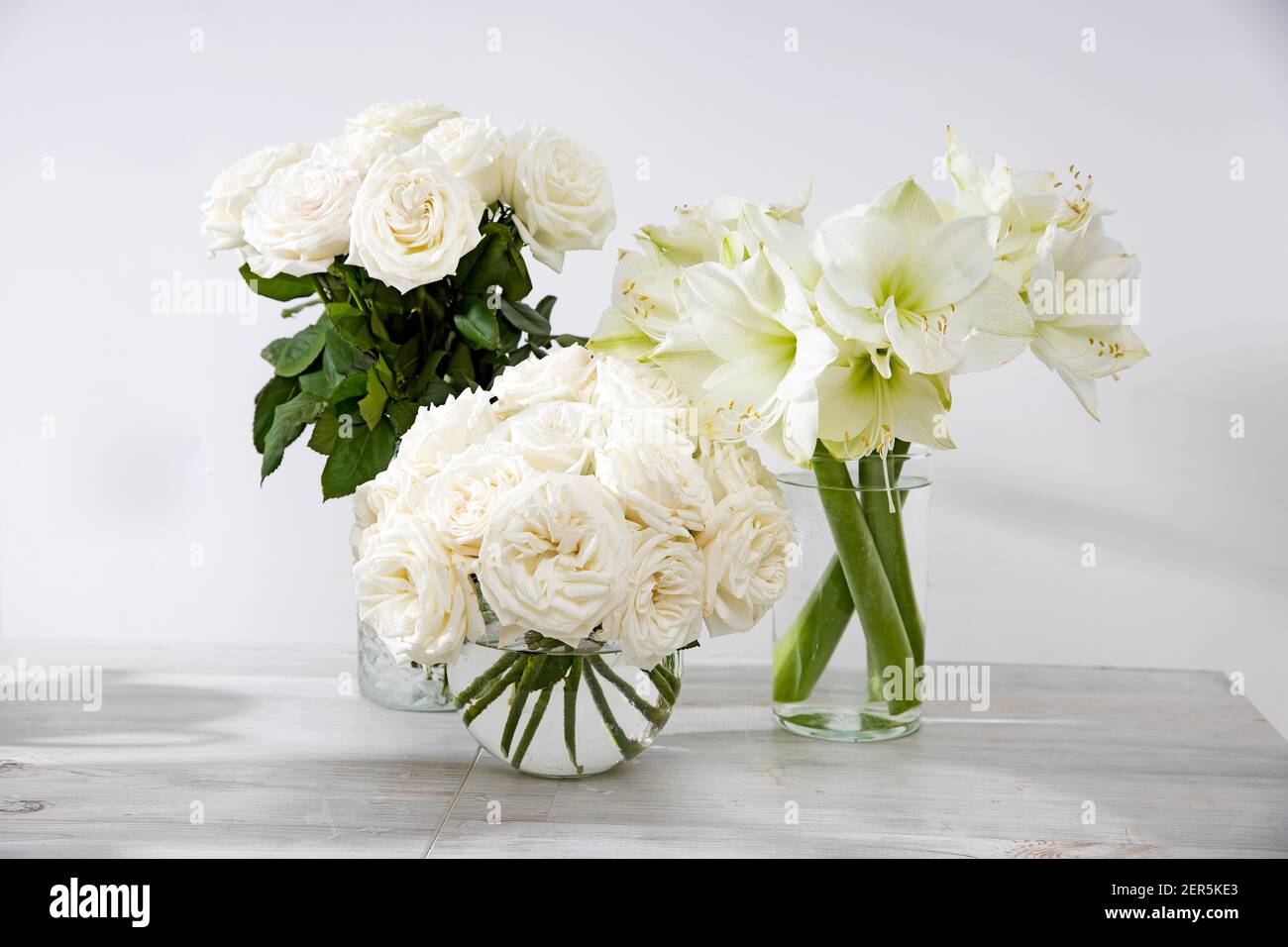 Roses blanches, nénuphar dans des vases ronds sur la table pour une occasion spéciale comme décoration de cuisine. Copier l'espace Banque D'Images