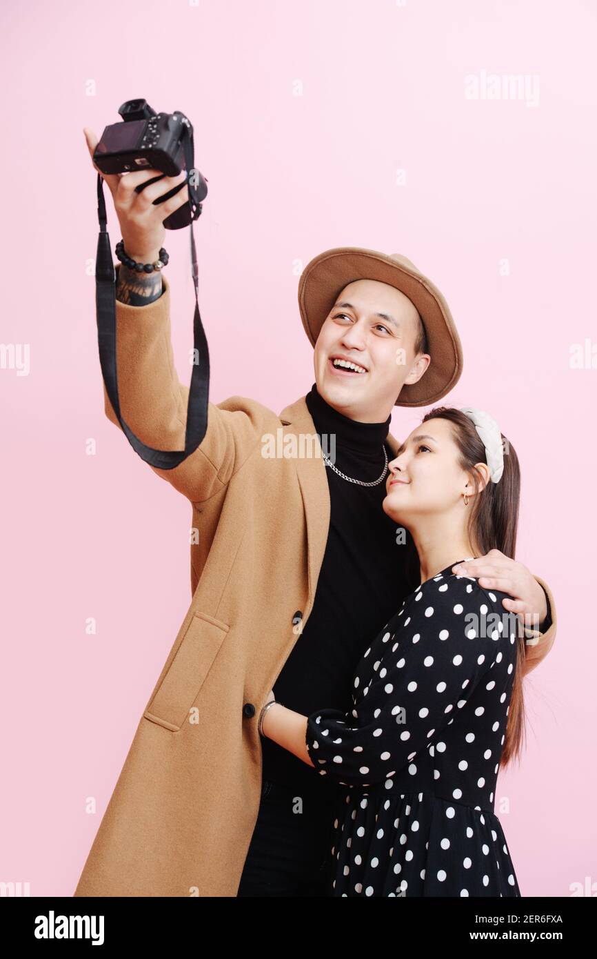Le jeune couple amoureux prend le selfie, emmêlé les uns aux autres. Image sur fond rose Banque D'Images