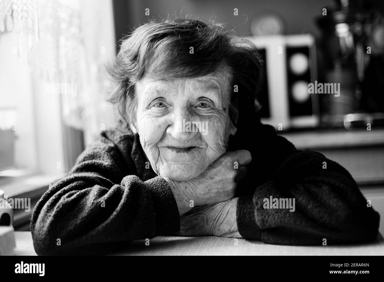 Portrait d'une vieille femme dans sa maison. Photo en noir et blanc. Banque D'Images
