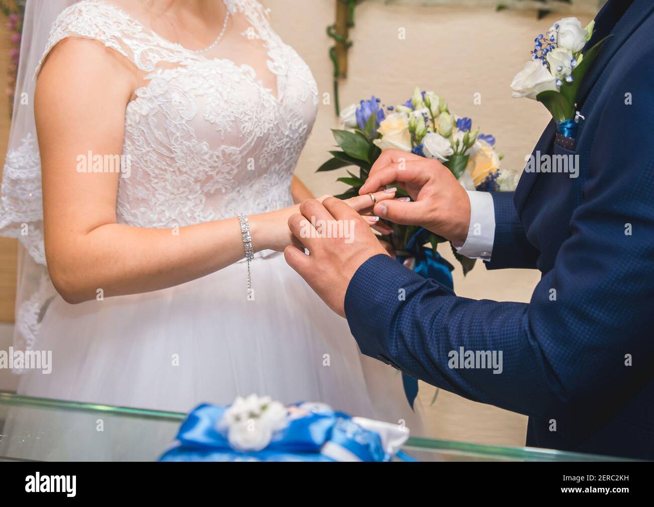 Partage des anneaux de mariage. Le marié met l'anneau sur le doigt de la mariée. Banque D'Images