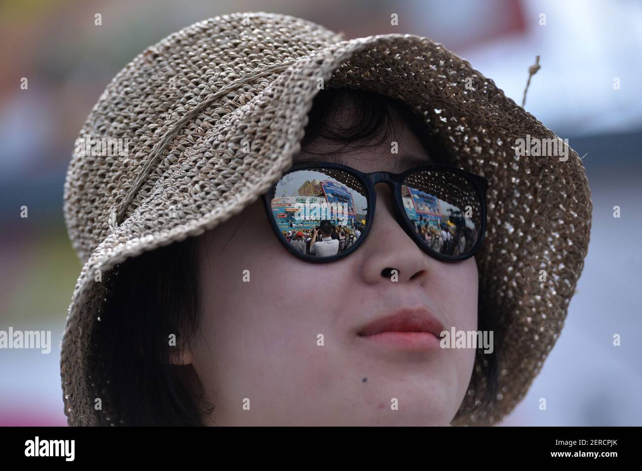 Reflet de la scène en lunettes à miroir lors du 102e concours annuel de  dégustation de hot dogs de Nathan, le 4 juillet 2018, à Coney Island, dans  le quartier de New