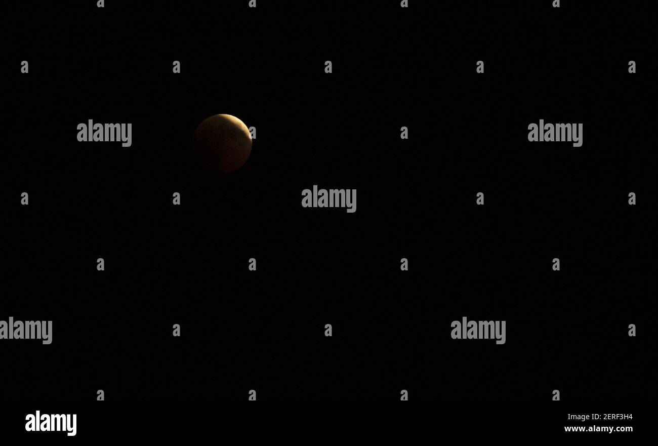 Une pleine lune s'élève sur le ciel de Tunis lors d'une éclipse lunaire complète à Tunis, en Tunisie, le 27 juillet 2018. La soi-disant ''lune de sang'' vendredi, quand elle devient rouge foncé, sera visible à différents moments en Australie, en Afrique, en Asie, en Europe et en Amérique du Sud quand le soleil, la Terre et la lune s'alignent parfaitement, jetant l'ombre de la Terre sur la lune. (Photo de Mohamed Krit/Sipa USA) Banque D'Images