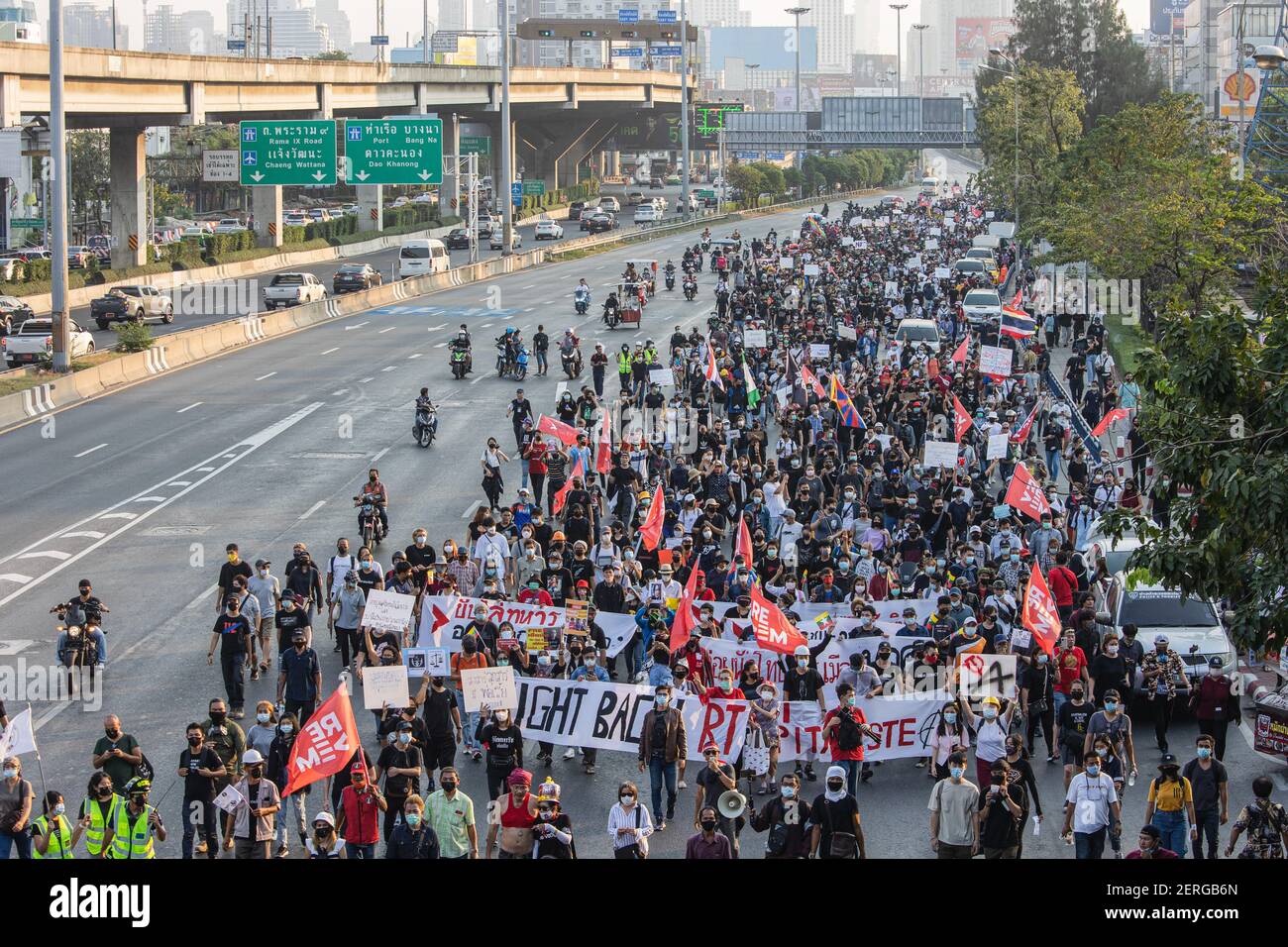 Des manifestants brandissant des banderoles et des pancartes défilés dans la rue pendant la manifestation.la manifestation pro-démocratie « ReDEM » (Restart Democracy) a donné le coup d'envoi de son premier rassemblement au Monument de la victoire. Ensuite, ils ont marché jusqu'au 1er Régiment d'infanterie, la résidence actuelle du Premier ministre Prayut Chan-o-cha. De la escarmouche au chaos, les deux côtés se sont rassemblés et empilés du côté opposé de la route de Vibhavadi Rangsit. La police de la zone de combat a changé d'équipement en balle de caoutchouc tandis que certains manifestants continuaient à lancer des rochers, des pétards et des bombes inconnues. Banque D'Images