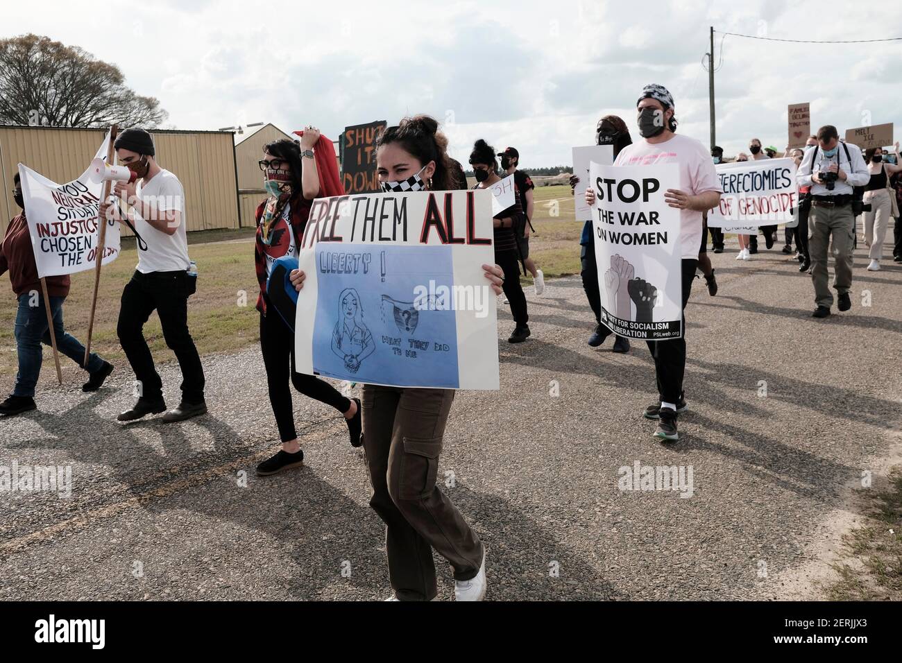 Ocilla, Géorgie, États-Unis. 28 février 2021. Un démonstrateur porte un panneau qui les lit TOUS libres tout en marchant au centre de détention du comté d'Irwin à Ocilla, GA. Le signe a aussi l'image d'une femme, à côté de l'image d'un ovaire manquant. L'image est une représentation du compte rendu de certaines femmes à l'établissement qui ont déclaré qu'elles avaient des hystérectomies exécutées sur elles sans leur consentement. Un dénonciateur nommé Dawn Wooten, qui travaillait comme infirmière à l'établissement, a d'abord allégué que les procédures étaient en cours en septembre 2020. Crédit : John Arthur Brown/ZUMA Wire/Alay Live News Banque D'Images