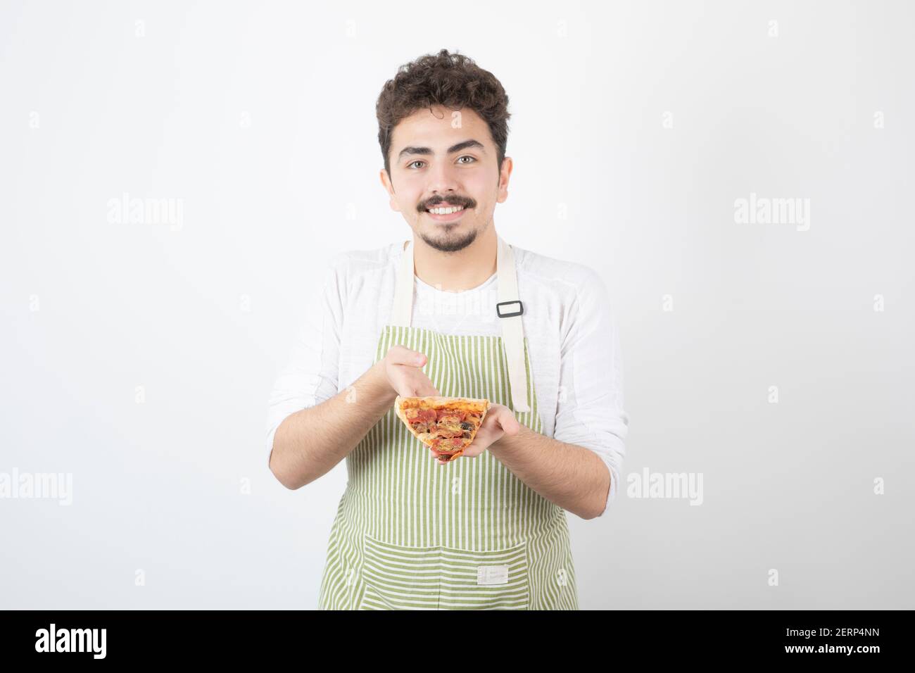 Prise de cuisinier mâle tenant une tranche de pizza sur blanc arrière-plan Banque D'Images