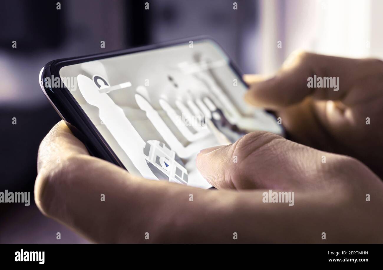 Joueur de téléphone jouant à un jeu mobile ou regardant un flux vidéo esports. Diffusion en direct, images/s, jeux. Le divertissement numérique dans une maison sombre. Concept de dépendance. Banque D'Images