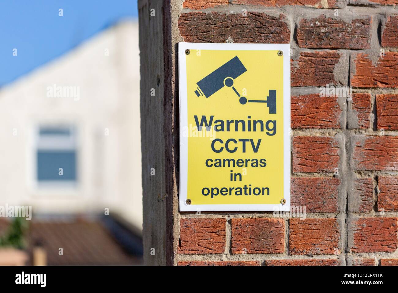 Un panneau d'avertissement de vidéosurveillance sur un mur de briques à l'extérieur d'un maison Banque D'Images