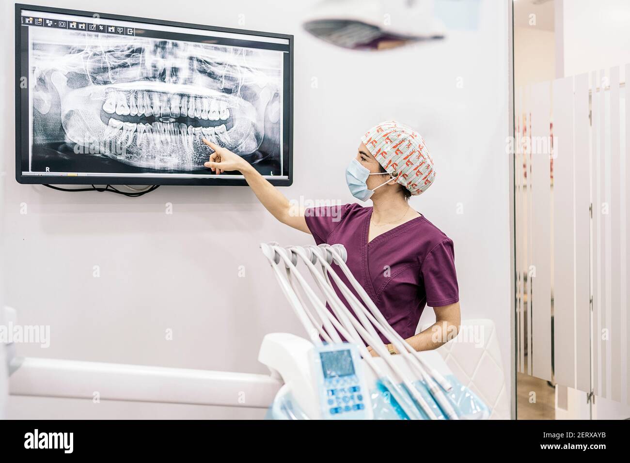 Photo de la femme dentiste montrant une radiographie de sa jeune patiente. Banque D'Images