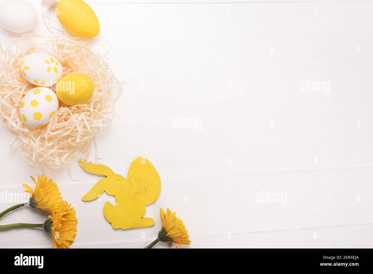 Oeufs de Pâques, fleurs, lapin jaune. Fond de printemps festif. Flat lay, vue de dessus, espace de copie Banque D'Images