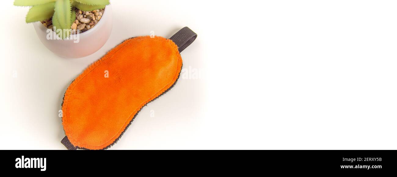 Vue de dessus d'un masque de sommeil orange et d'une fleur, une attitude positive au sommeil, une bannière avec une copie de l'espace et un endroit pour votre texte Banque D'Images