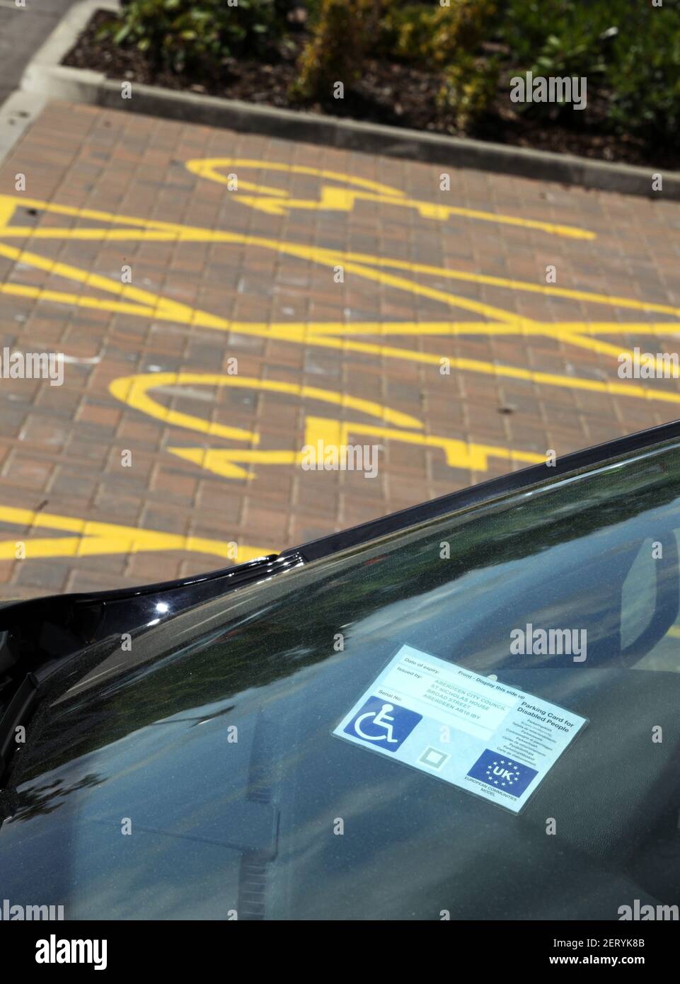 Pare-brise affichant un badge de conducteur handicapé et des marquages pour les détenteurs d'un badge de conducteur handicapé uniquement dans un parking en Écosse, au Royaume-Uni Banque D'Images