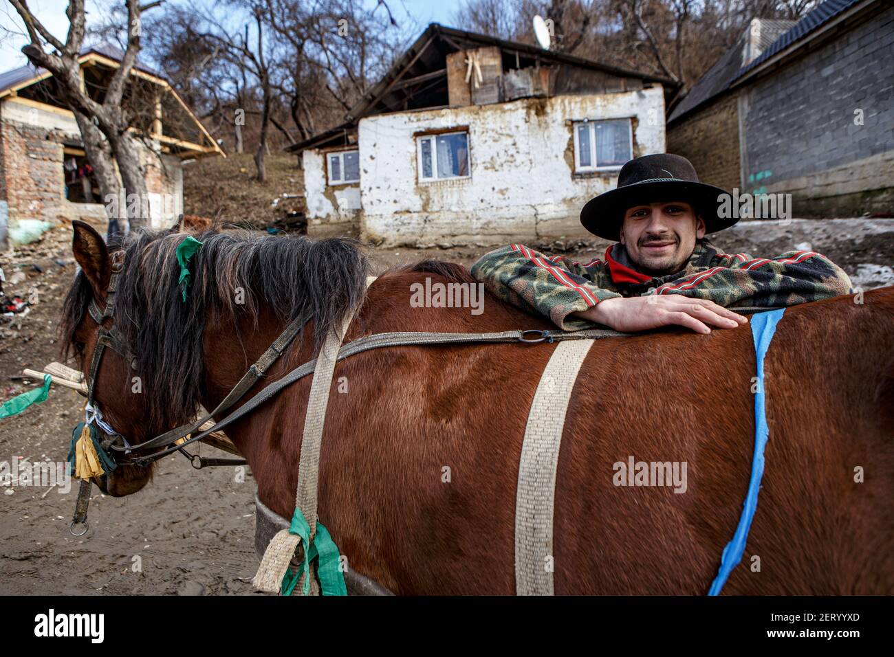VELYKYI BEREZNYI, UKRAINE - 28 FÉVRIER 2021 - Milan pose avec son cheval dans le camp ROM de Velykyyi Bereznyi village urbain, Zakarpattia R. Banque D'Images