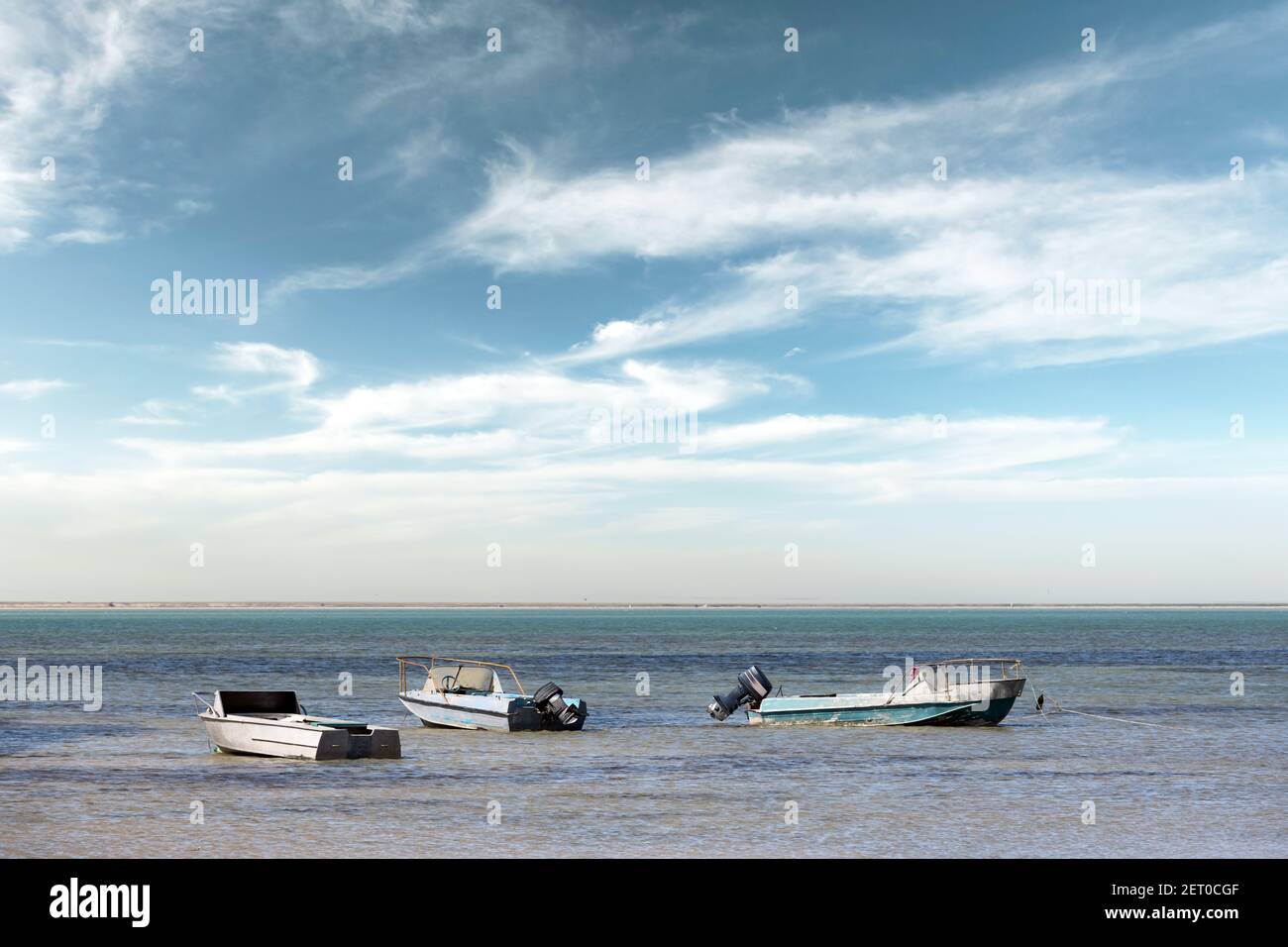 Vieux bateaux en métal sur l'eau de mer noire claire. Ciel bleu avec des nuages sur l'arrière-plan Banque D'Images