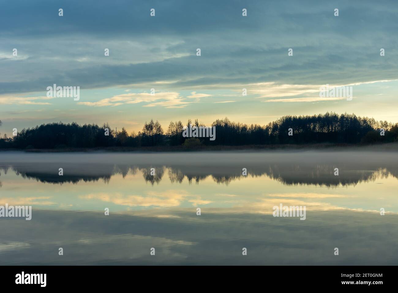 Brouillard sur un lac calme, arbres et nuages du soir, Stankow, Lubelskie, Pologne Banque D'Images