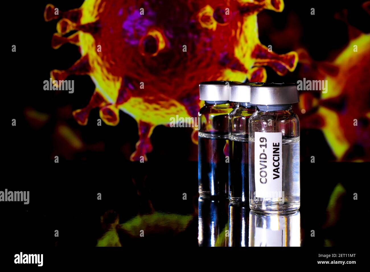Flacons en verre avec vaccin contre le virus Covid-19 et microscopique contre le virus Covid image en arrière-plan Banque D'Images