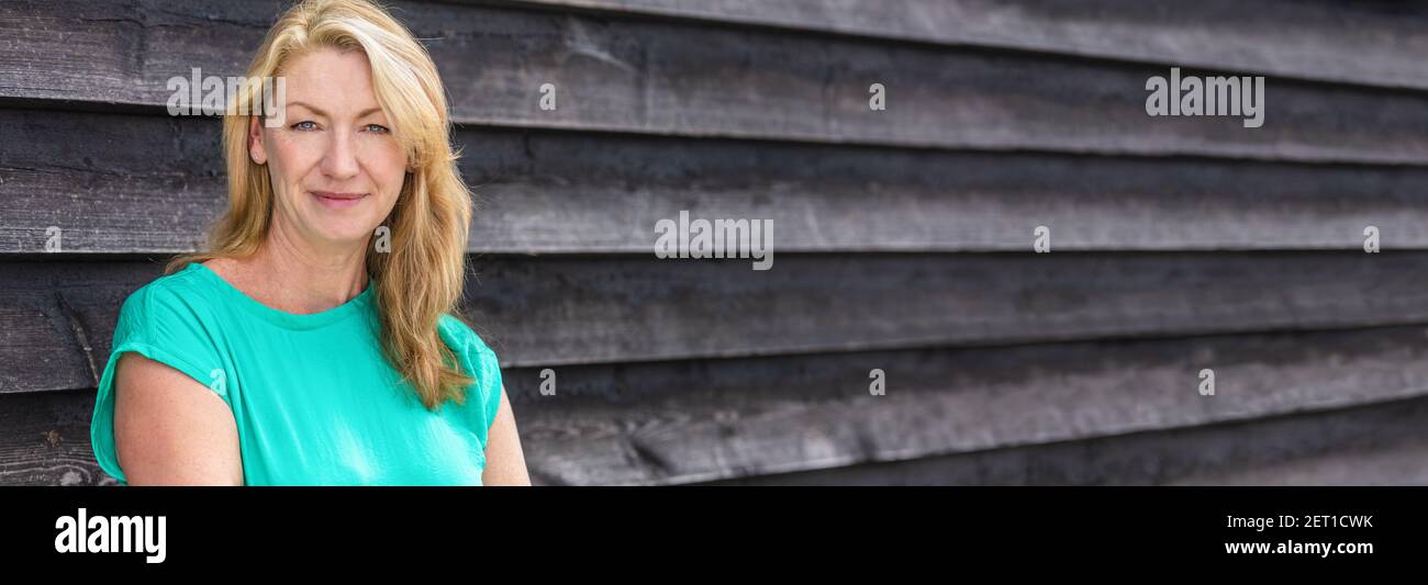Portrait panoramique d'une jolie femme blonde d'âge moyen en-tête de bannière web panoramique souriant Banque D'Images