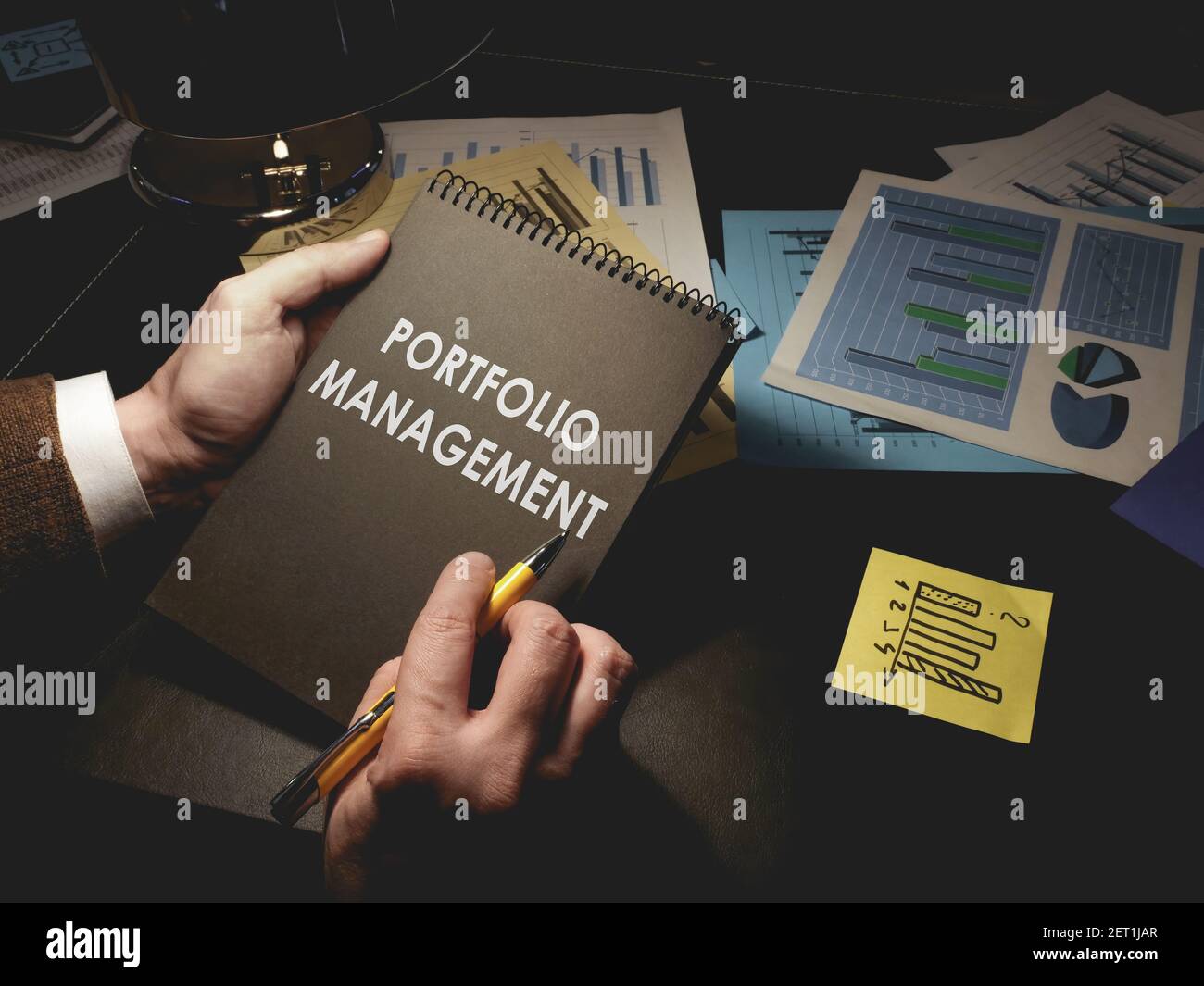 Man prend des notes sur la gestion de portefeuille dans le bloc-notes. Banque D'Images