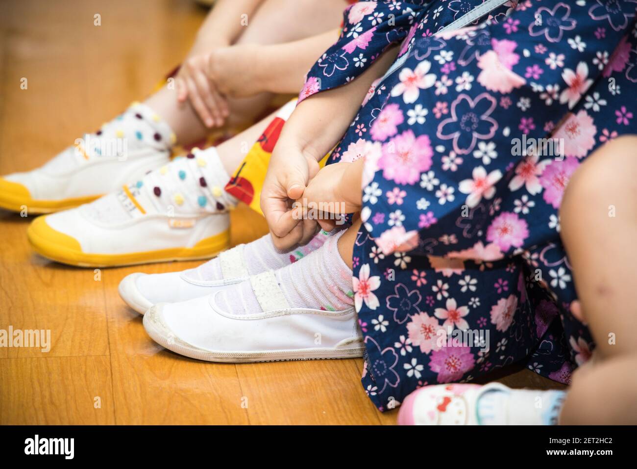 Enfants japonais dans les kimono et yukata assis sur le sol Banque D'Images