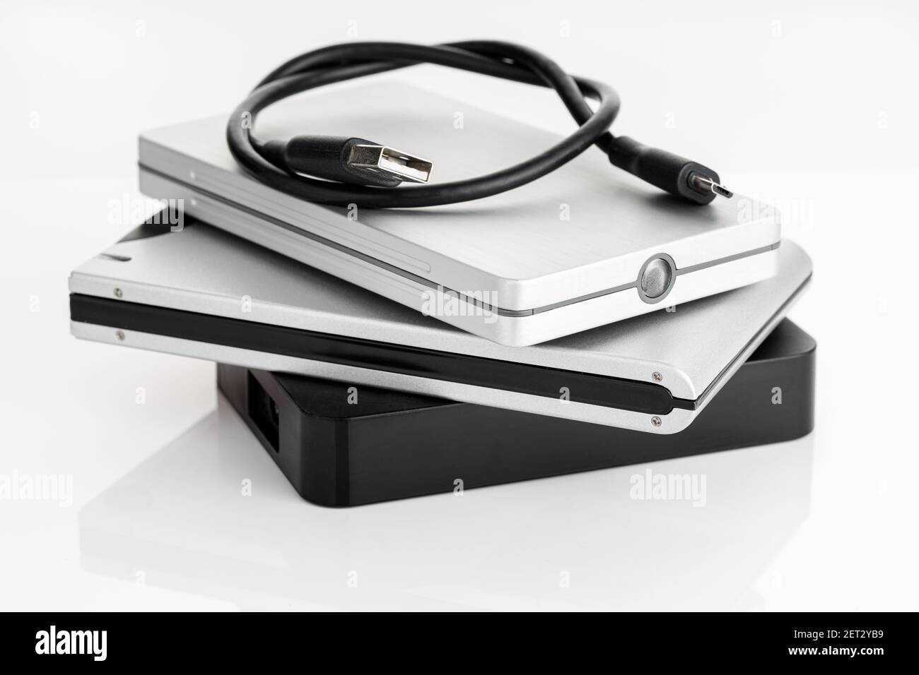 Pile d'un groupe de disques durs externes sur une table blanche. Concept de stockage de données sur disque dur Banque D'Images