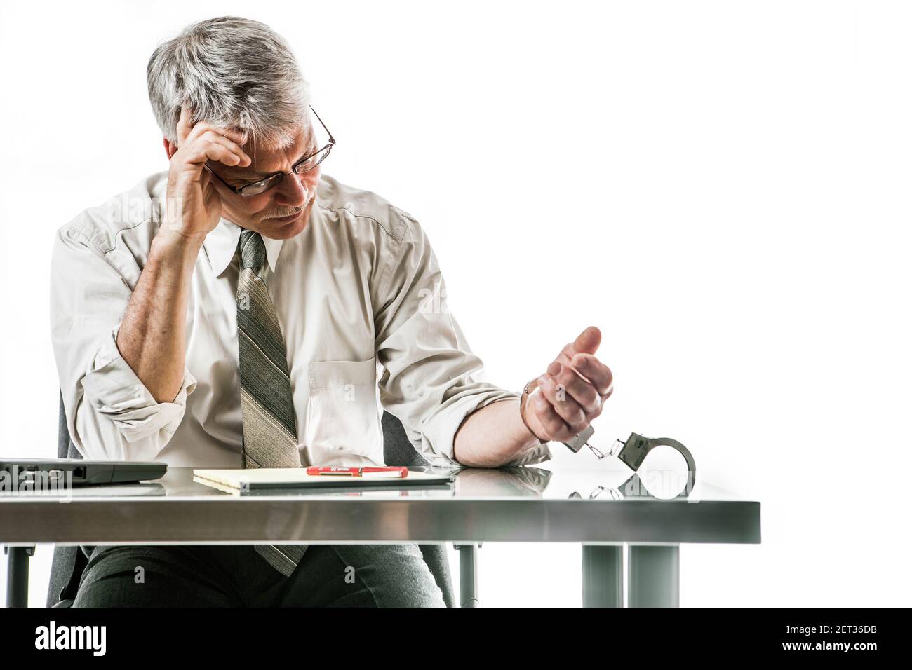 Un homme d'affaires menotté à son bureau. Concept d'entreprise. Banque D'Images