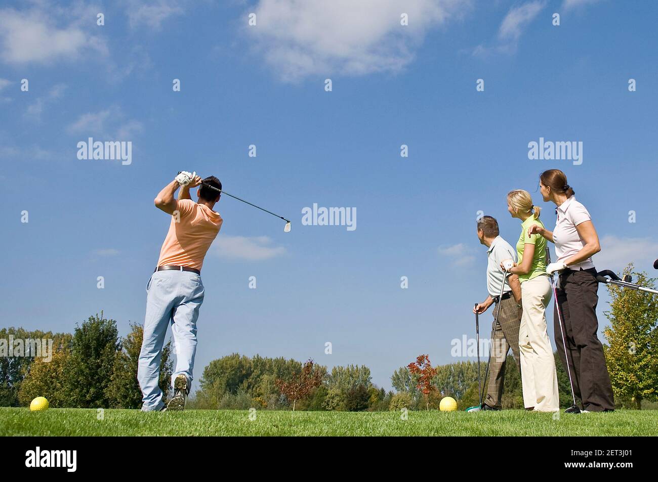 Les golfeurs observant le joueur tout en frappant une balle du tee Banque D'Images